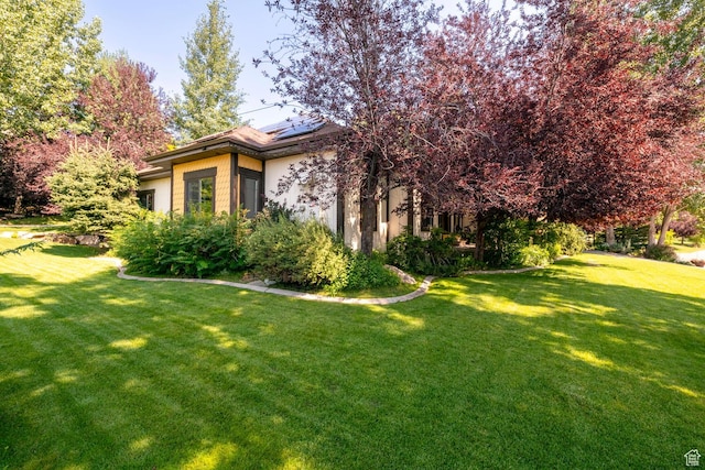 view of home's exterior with solar panels and a lawn