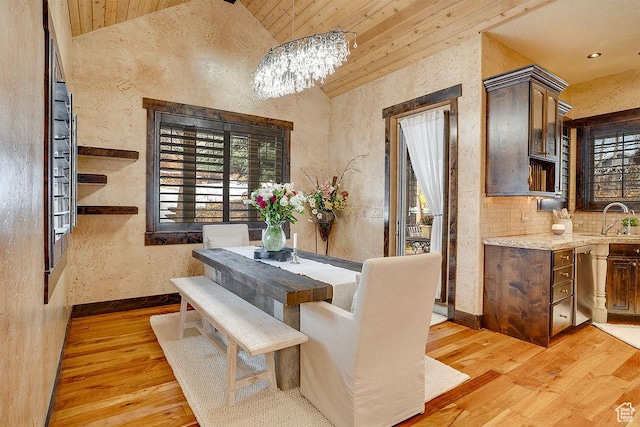 dining room with lofted ceiling, wooden ceiling, baseboards, and light wood finished floors