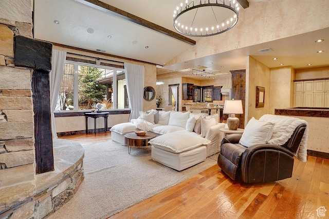 living room featuring visible vents, hardwood / wood-style flooring, beamed ceiling, an inviting chandelier, and high vaulted ceiling