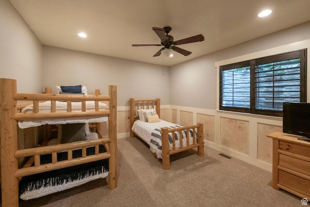 bedroom featuring light colored carpet, a wainscoted wall, visible vents, and recessed lighting