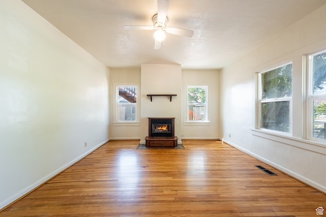 89 W 100 S, Kanab, UT 84741 - unfurnished living room with ceiling fan, light hardwood / wood-style flooring, a wealth of natural light, and a wood stove