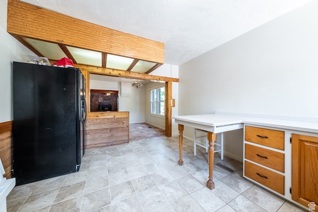 89 W 100 S, Kanab, UT 84741 - interior space featuring light tile patterned flooring, black fridge, and a textured ceiling