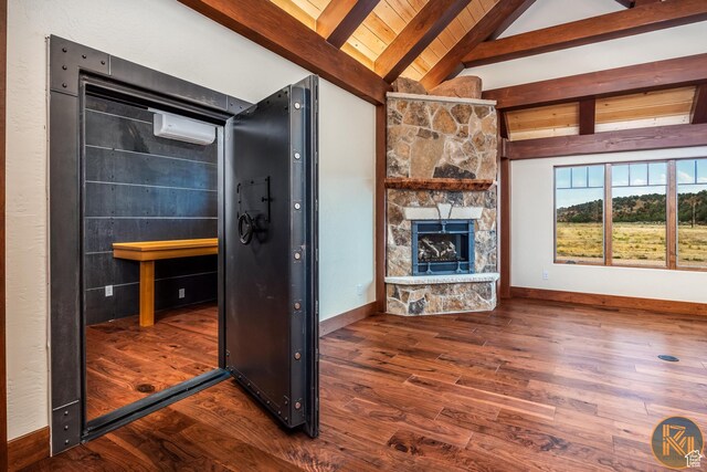 5605 N Johnson Canyon Rd, Kanab, UT 84741 - unfurnished living room featuring a stone fireplace, wood finished floors, an AC wall unit, and baseboards