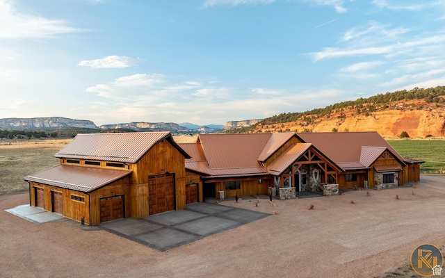 5605 N Johnson Canyon Rd, Kanab, UT 84741 - rustic home featuring dirt driveway, metal roof, a detached garage, a mountain view, and stone siding