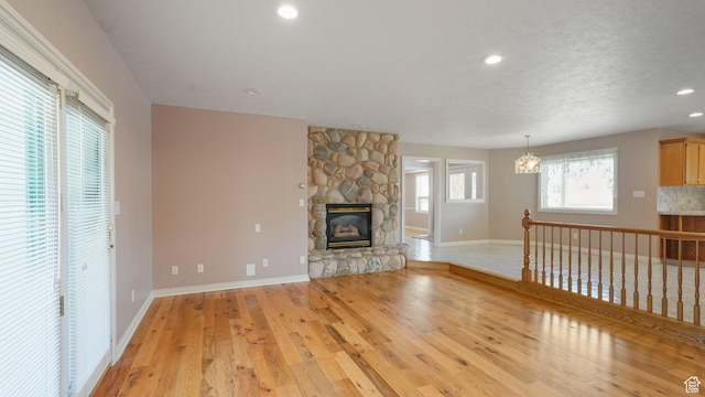 401 N Fairgrounds Rd, Price, UT 84501 - unfurnished living room with a stone fireplace and light hardwood / wood-style flooring