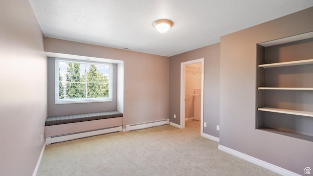 401 N Fairgrounds Rd, Price, UT 84501 - unfurnished bedroom with a walk in closet, a baseboard radiator, a closet, and light carpet