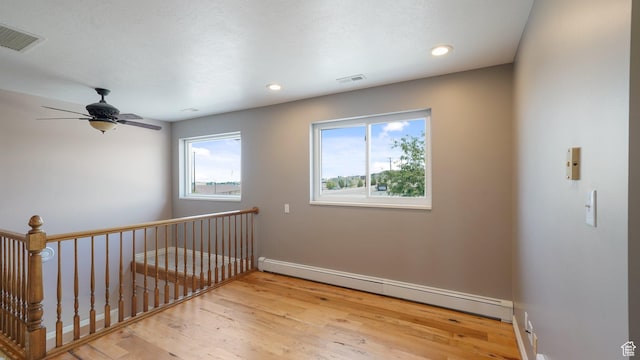 401 N Fairgrounds Rd, Price, UT 84501 - unfurnished room featuring light hardwood / wood-style flooring, a baseboard radiator, ceiling fan, and plenty of natural light