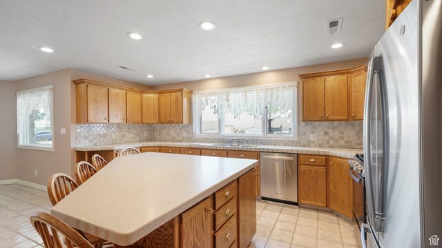 401 N Fairgrounds Rd, Price, UT 84501 - kitchen with a kitchen bar, sink, a kitchen island, stainless steel appliances, and backsplash