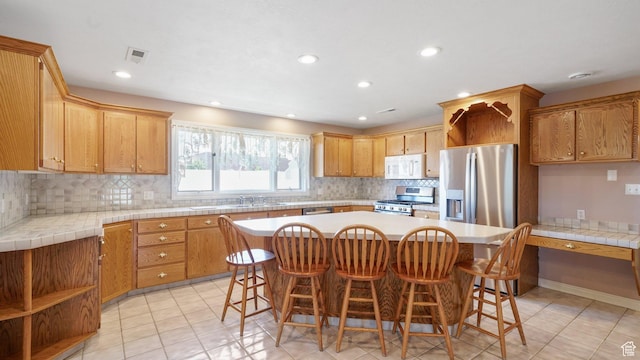 401 N Fairgrounds Rd, Price, UT 84501 - kitchen with sink, a breakfast bar area, a center island, appliances with stainless steel finishes, and backsplash