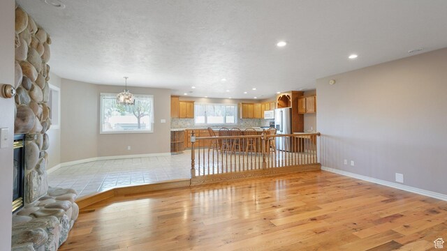 401 N Fairgrounds Rd, Price, UT 84501 - unfurnished living room with a stone fireplace and light hardwood / wood-style flooring