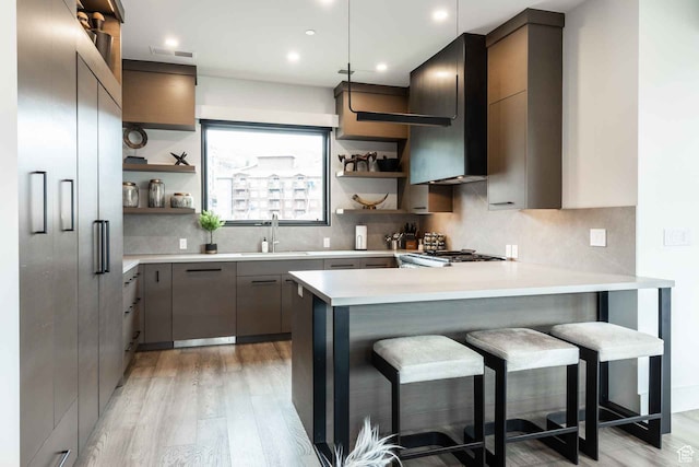 3599 Ridgeline Dr Unit 2, Park City, UT 84098 - kitchen with sink, kitchen peninsula, decorative light fixtures, light wood-type flooring, and a kitchen breakfast bar