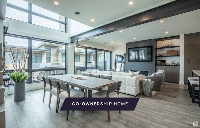 dining space with light hardwood / wood-style flooring, a fireplace, and ceiling fan