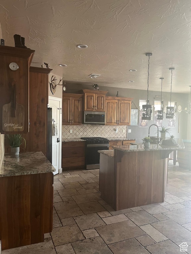 650 N Red Stone Rd Unit 22, Washington, UT 84780 - kitchen featuring stainless steel microwave, stone tile floors, tasteful backsplash, and range with gas stovetop