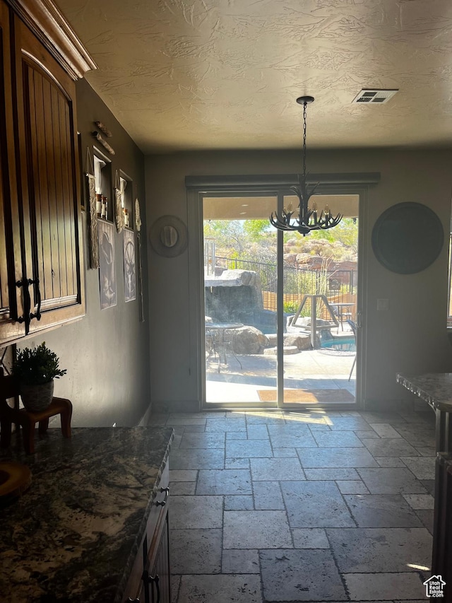 650 N Red Stone Rd Unit 22, Washington, UT 84780 - unfurnished dining area with stone tile floors, a notable chandelier, and visible vents