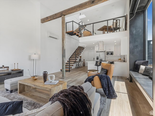 231 S Edison St E Unit 7, Salt Lake City, UT 84111 - living area with a towering ceiling, stairway, light wood-style floors, an AC wall unit, and beam ceiling