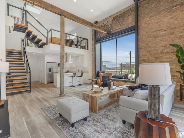 231 S Edison St E Unit 7, Salt Lake City, UT 84111 - living area with a high ceiling, stairway, light wood finished floors, and brick wall