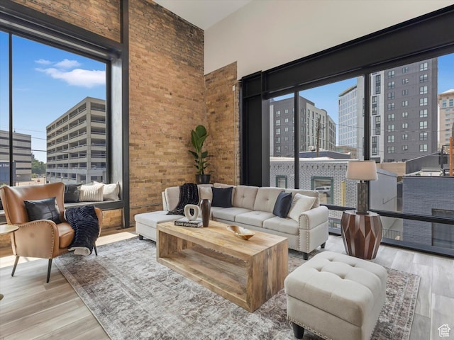 231 S Edison St E Unit 7, Salt Lake City, UT 84111 - living room featuring a view of city, wood finished floors, a high ceiling, and brick wall