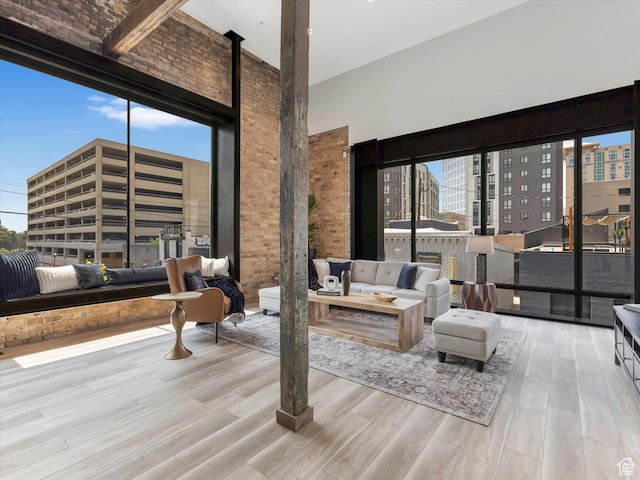 231 S Edison St E Unit 7, Salt Lake City, UT 84111 - living area with wood finished floors, a towering ceiling, and brick wall