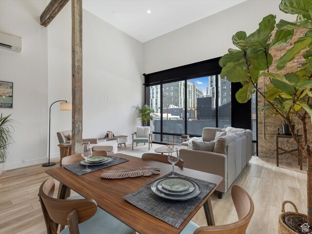 231 S Edison St E Unit 3, Salt Lake City, UT 84111 - dining space featuring a towering ceiling, light wood-style flooring, a wall mounted AC, and a city view