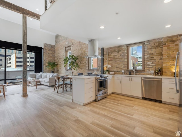 231 S Edison St E Unit 3, Salt Lake City, UT 84111 - kitchen with stainless steel appliances, exhaust hood, light wood-style floors, a high ceiling, and light countertops