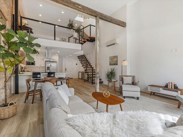 231 S Edison St E Unit 3, Salt Lake City, UT 84111 - living room with stairway, a towering ceiling, light wood-style flooring, a wall unit AC, and recessed lighting