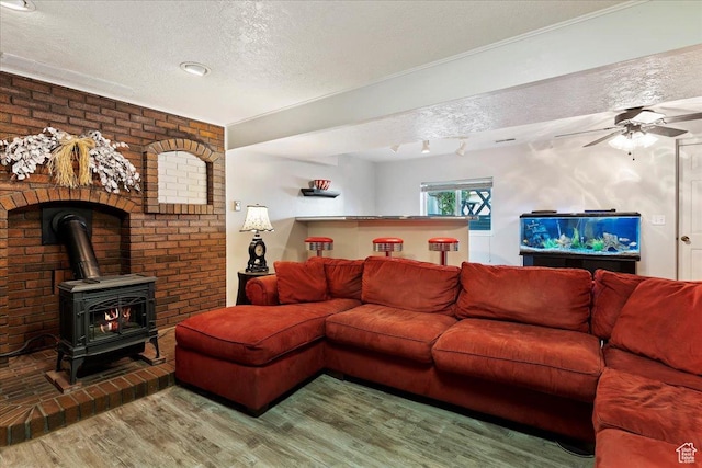 1154 W 1700 S, Syracuse, UT 84075 - living area with brick wall, a textured ceiling, a ceiling fan, a wood stove, and wood finished floors