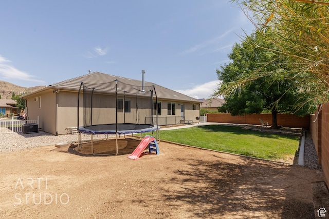 267 N 250 W, La Verkin, UT 84745 - back of house featuring a trampoline, a lawn, a fenced backyard, and stucco siding