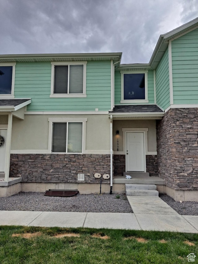 property entrance featuring stone siding and stucco siding