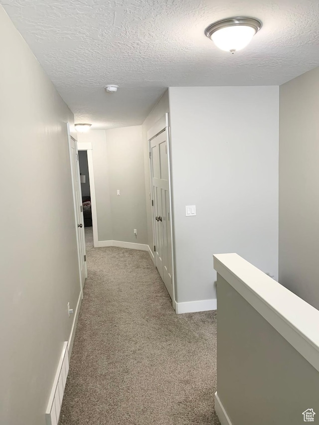 1999 E Abbey Way, Eagle Mountain, UT 84005 - hallway featuring visible vents, baseboards, a textured ceiling, and light colored carpet