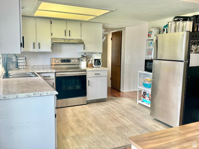 805 E 2910 S, Vernal, UT 84078 - kitchen with under cabinet range hood, appliances with stainless steel finishes, light countertops, and light wood-style floors