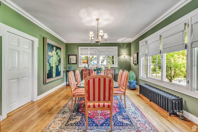dining room with crown molding, radiator heating unit, light wood-type flooring, and a notable chandelier