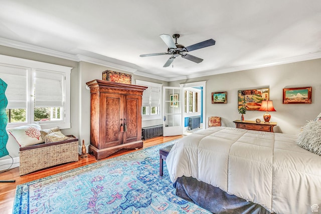 bedroom featuring radiator, crown molding, light hardwood / wood-style floors, and ceiling fan