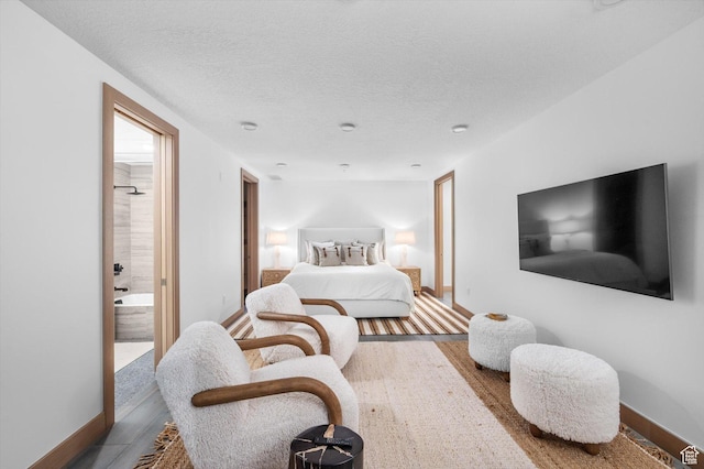 1271 Lowell Ave Unit B-103, Park City, UT 84060 - bedroom with baseboards, wood finished floors, ensuite bathroom, and a textured ceiling
