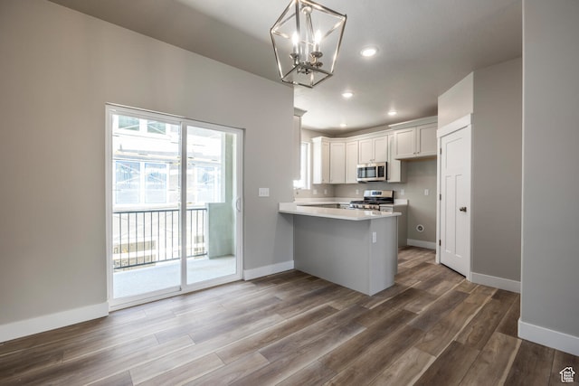 1072 S 2760 E, Spanish Fork, UT 84660 - kitchen with appliances with stainless steel finishes, kitchen peninsula, dark wood-type flooring, and white cabinetry
