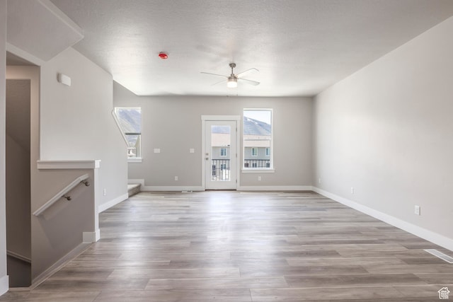 1072 S 2760 E, Spanish Fork, UT 84660 - unfurnished living room featuring a textured ceiling, ceiling fan, and hardwood / wood-style floors