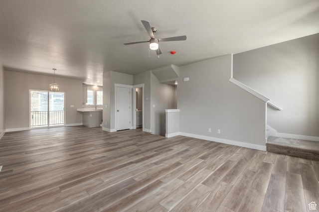 1072 S 2760 E, Spanish Fork, UT 84660 - unfurnished living room with ceiling fan with notable chandelier and hardwood / wood-style flooring