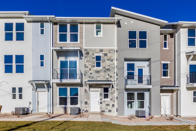 townhome / multi-family property featuring a balcony and central air condition unit