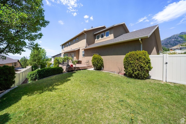 1566 E 300 S, Pleasant Grove, UT 84062 - back of house with stucco siding, a gate, a deck, fence, and a lawn