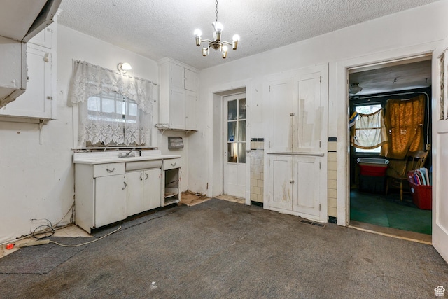 933 W Gentile St, Layton, UT 84041 - kitchen with visible vents, a textured ceiling, white cabinetry, carpet floors, and an inviting chandelier