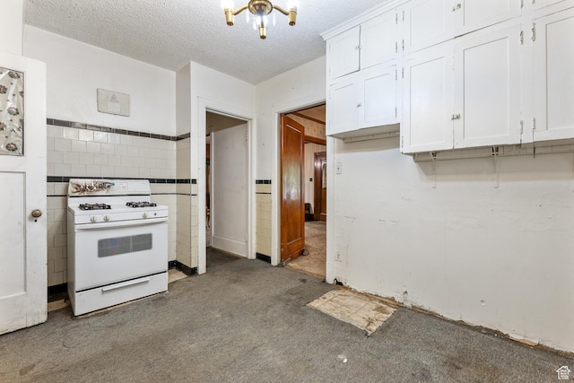 933 W Gentile St, Layton, UT 84041 - kitchen with a textured ceiling, carpet, gas range gas stove, wainscoting, and white cabinetry