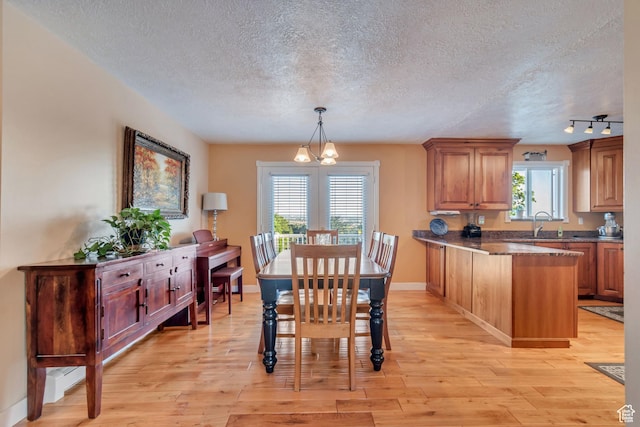 751 W 3500 N, Pleasant View, UT 84414 - dining area featuring rail lighting, sink, an inviting chandelier, a textured ceiling, and light wood-type flooring
