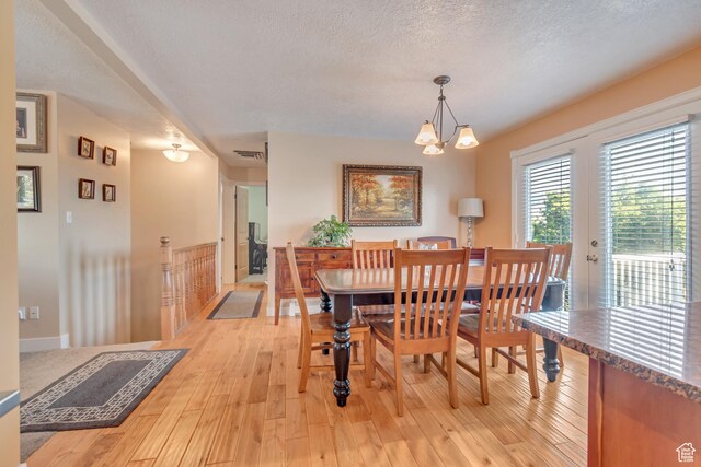 751 W 3500 N, Pleasant View, UT 84414 - dining space with an inviting chandelier, a textured ceiling, light hardwood / wood-style floors, and french doors