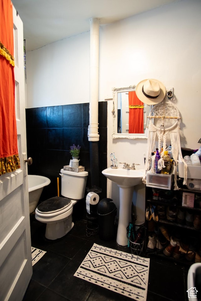 bathroom with sink, tile walls, tile patterned floors, and toilet
