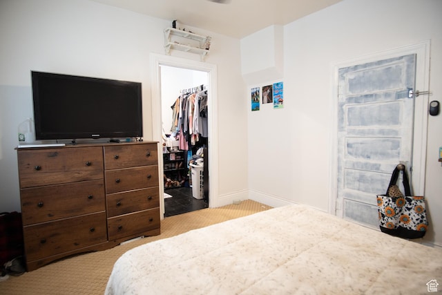 carpeted bedroom featuring a walk in closet and a closet