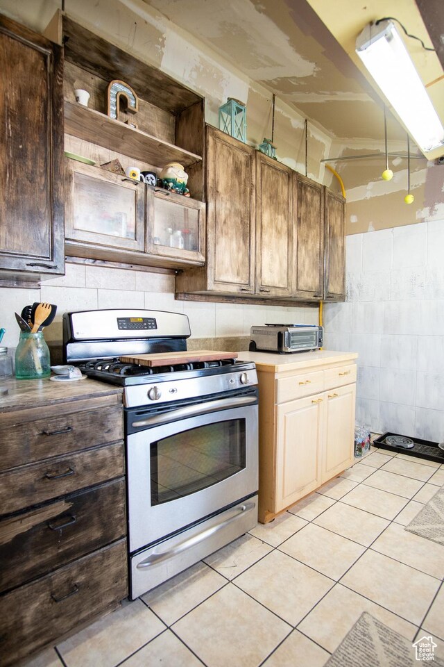 kitchen with stainless steel gas stove and light tile patterned floors
