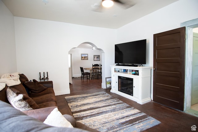 living room with dark hardwood / wood-style flooring and ceiling fan