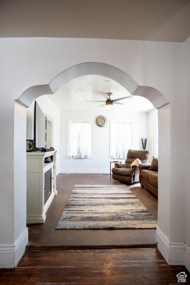 interior space with dark wood-type flooring and ceiling fan