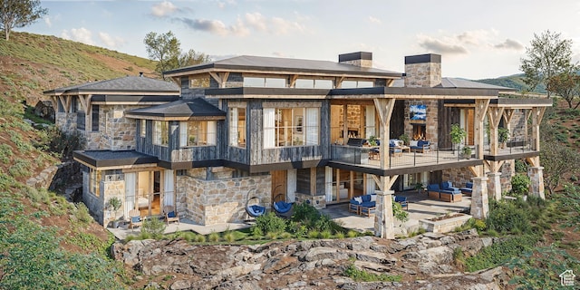 1771 N Chimney Rock Rd Unit 521, Heber City, UT 84032 - back of property with stone siding, a patio, a chimney, a balcony, and an outdoor living space