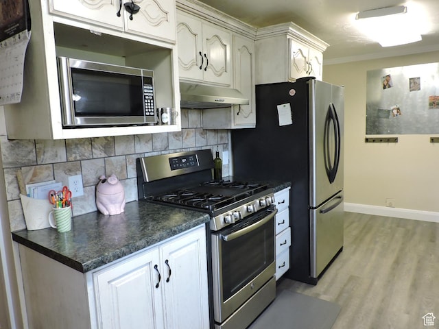 325 N 100 W, Delta, UT 84624 - kitchen with under cabinet range hood, dark countertops, backsplash, and appliances with stainless steel finishes