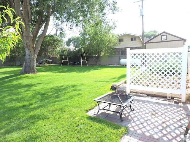 325 N 100 W, Delta, UT 84624 - view of yard featuring a playground, a trampoline, a fenced backyard, a fire pit, and a patio area